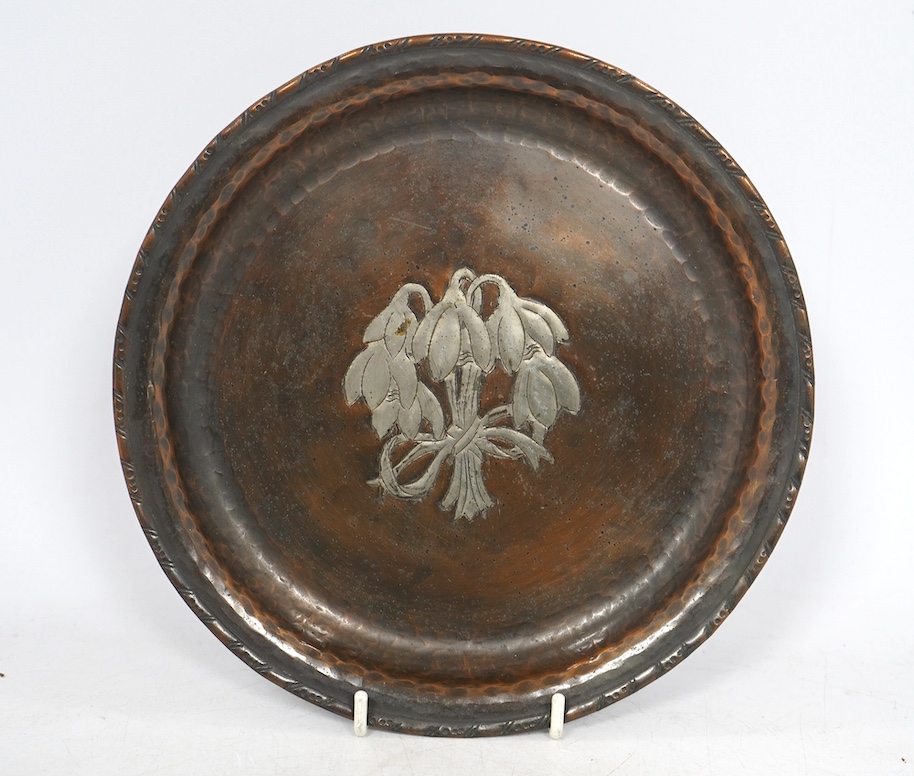 A Hugh Wallis Arts & Crafts small copper and pewter tray decorated with snowdrops, stamped HW, diameter 19.5cm. Condition - fair